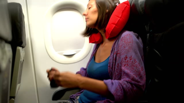 A-woman-in-a-plane-dresses-a-mask-for-sleep