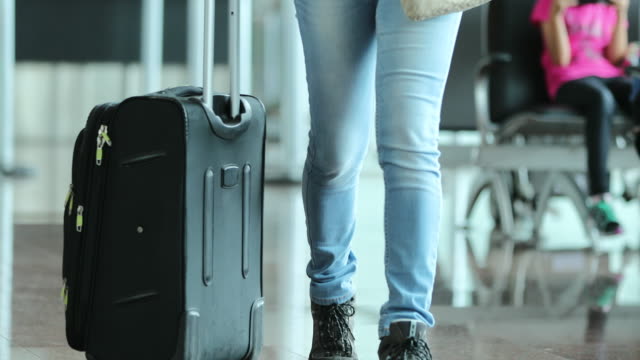 Person-pulls-suitcase-at-the-airport.-Woman-carrying-luggage-in-4K