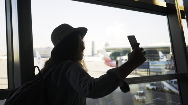 Frau,-die-Selfie-in-der-Nähe-von-Flughafen-Fenster