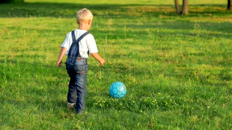 Elementary-aged-boy-kicking-ball-in-the-field