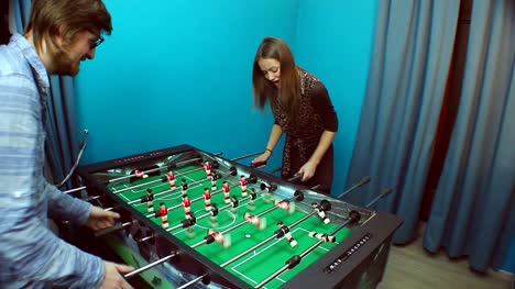 Beautiful-girl-young-guy-playing-table-soccer,-chatting-on-date