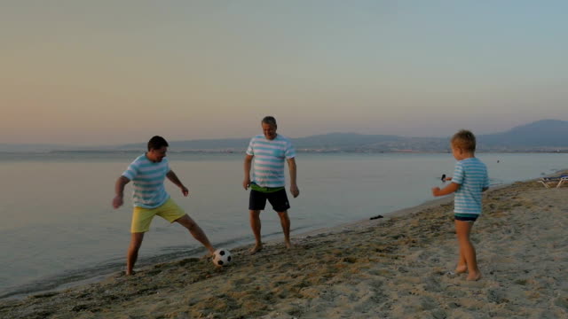 Familie-Fußball-spielen-am-Strand