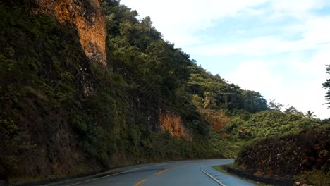 View-from-the-car-driving-by-the-asphalt-road-in-Puerto-Plata,-Dominican-Republic