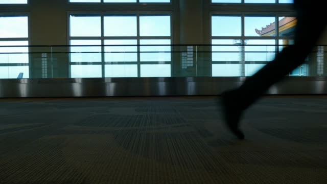 People-walk-inside-airport-terminal,-timelapse.