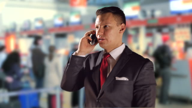 Hombre-de-negocios-del-aeropuerto-en-que-habla-del-teléfono-móvil-y-viajes,-corbata-roja-y-traje