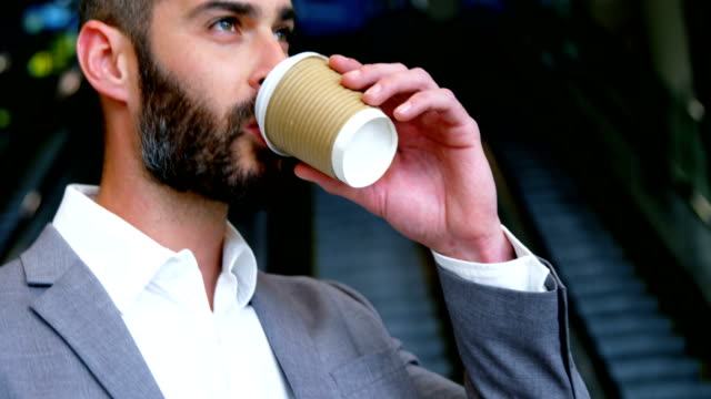 Businessman-having-coffee-from-disposable-cup