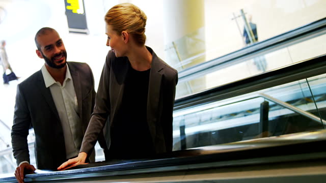 Business-people-interacting-on-an-escalator