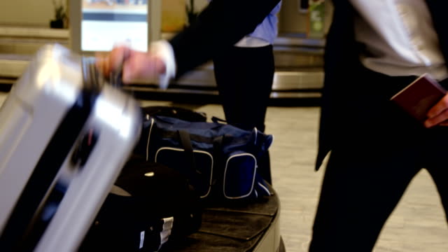 Businessman-taking-his-luggage-off-the-baggage-carousel