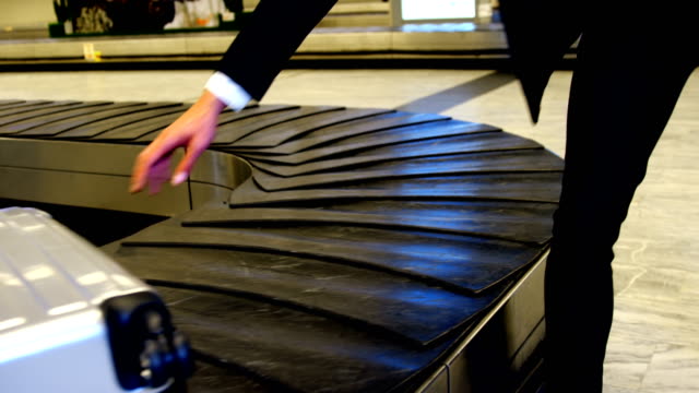 Businessman-taking-his-luggage-off-the-baggage-carousel