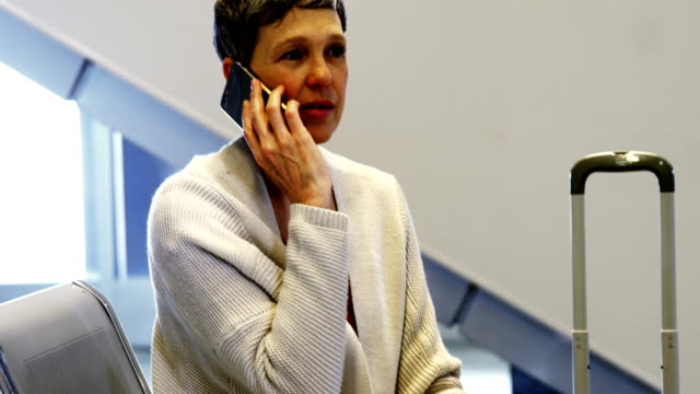 Mujer-hablando-por-teléfono-móvil-en-la-zona-de-espera