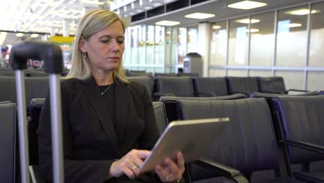 Mujer-de-negocios-usando-tableta-digital-en-el-aeropuerto