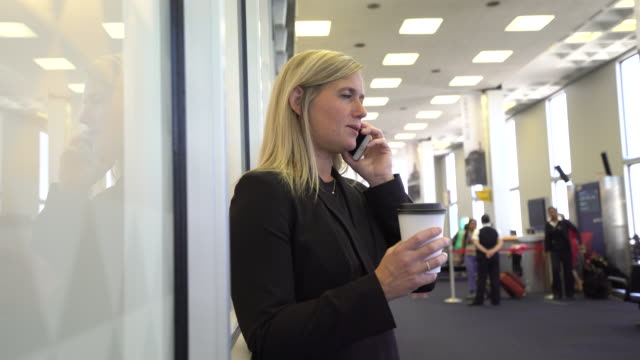 Business-woman-using-cell-phone-at-airport