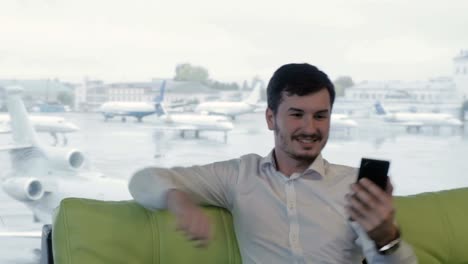 Hombre-de-negocios-toma-un-selfie-en-el-pasillo-de-salón-del-aeropuerto