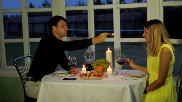 Schönes-Paar-sitzt-im-Restaurant,-der-Mann-Hand-Feed-seiner-Freundin-Kanapees