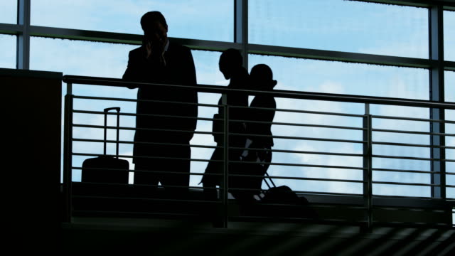 Silhouette-der-Businessmanager-im-Flughafen-mit-mobilen