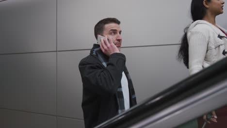 Businessman-on-escalator-talking-on-cell-phone