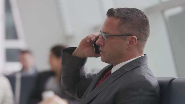 Businessman-talking-on-cell-phone-at-airport