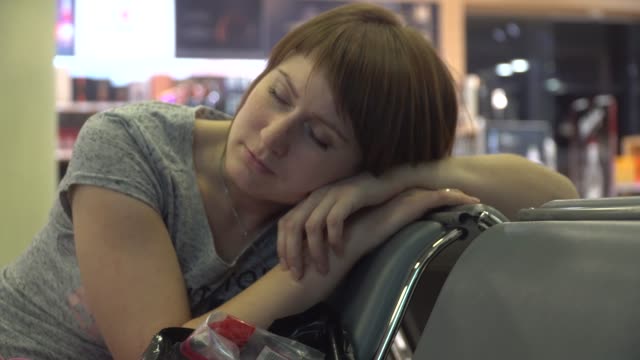Frau-schläft-auf-dem-Flughafengelände-warten.-Flugverspätung