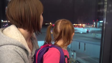 Ein-kleines-Mädchen-mit-Mutter-schaut-die-Flugzeuge-am-Flughafen