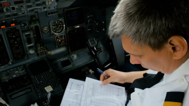 Captain-of-airplane-checks-documents-before-flight