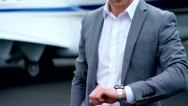 Businessman-checking-time-while-standing-on-a-runaway-4k