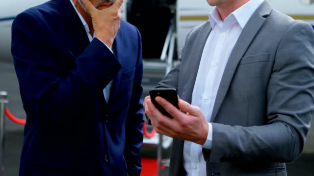 Businessmen-discussing-over-mobile-phone-4k