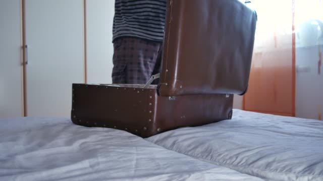 Ein-Mann-packt-einen-Koffer-im-Urlaub
