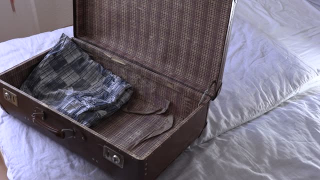 Ein-Mann-packt-einen-Koffer-im-Urlaub,-Slow-Motion-video