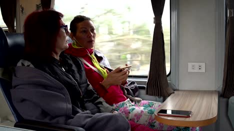 Women-sit-on-the-train-and-talk