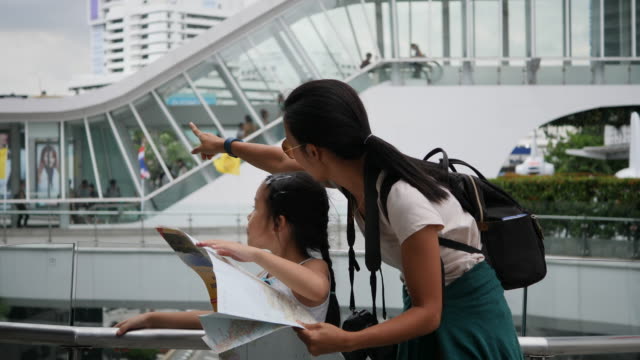 Mother-and-daughter-looking-a-map-backpack-travel-in-the-city