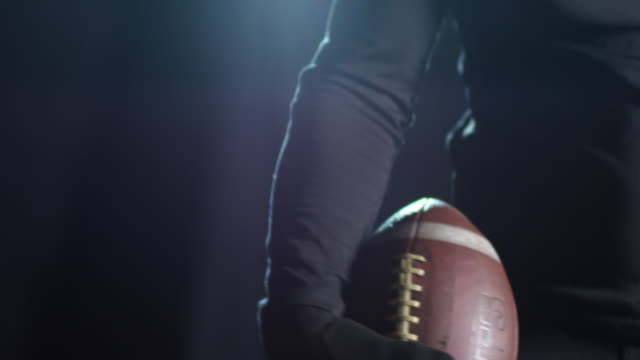 Sportsman-Holding-Football-Ball-on-Black-Background