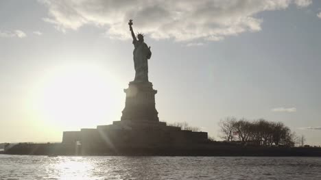 Medium-shot-der-Statue-of-Liberty,-gefilmt-in-den-Sonnenuntergang-vom-Fluss-in-New-York,-Vereinigte-Staaten-von-Amerika