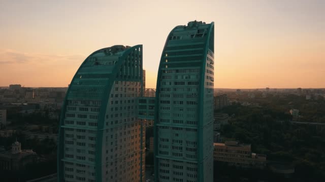 Silhouette-des-doppelten-hoch-Skyscrapper-mit-Brücke-zwischen-ihnen-gegen-Sonnenuntergang