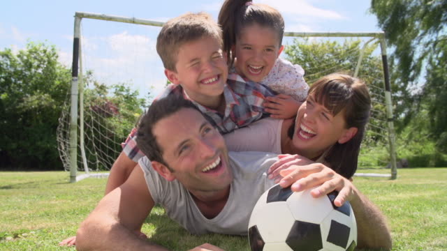 Familie-spielen-Fußball-In-Garden-Together