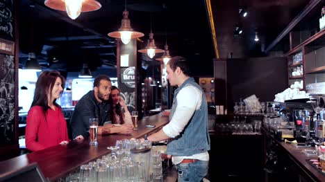 Two-cute-girls-and-a-guy-make-an-order-to-the-bartender