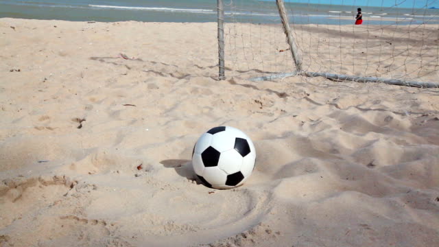 Fútbol-y-objetivo-en-la-playa-de-arena-y-el-cielo-azul-de-fondo-de-tracking,-dolly-en-HD-de-tomas-a-cámara-de-luz-de-día
