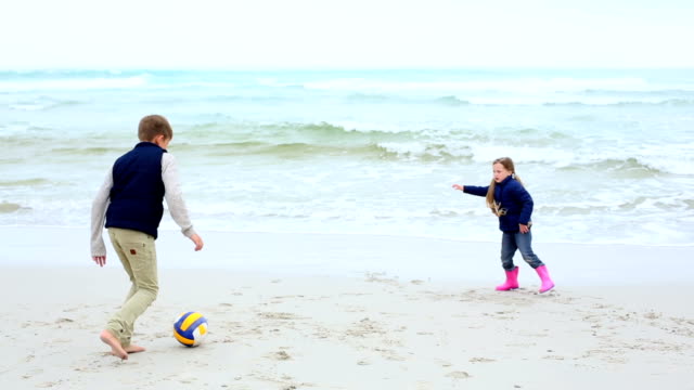 Hermanos-jugar-al-fútbol-en-la-playa