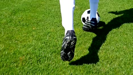 Footballer-leading-the-ball-on-a-football-field,-slow-motion