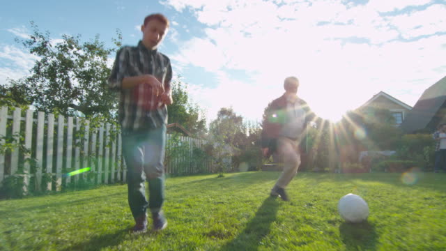 Abuelo-y-nieto-juegan-al-fútbol-en-el-patio-trasero.