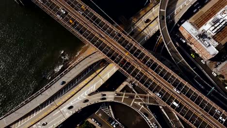 Vista-aérea-superior-del-tráfico-por-carretera-en-Nueva-York,-América.-Drone-volando-sobre-intersección-de-tráfico-en-la-orilla-de-East-river