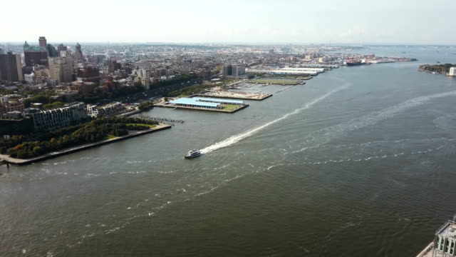 Aerial-view-of-the-East-river,-boat-riding-through-the-water-near-the-downtown-of-Brooklyn-in-New-York,-America