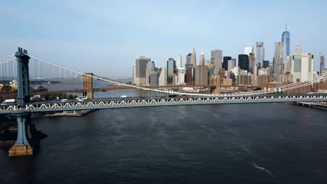 Aerial-view-of-the-skyscrapers-in-downtown-in-New-York,-America.-Manhattan-bridge-going-through-the-East-river