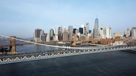 Vista-aérea-de-Nueva-York,-América.-Drone-volando-bajo-del-puente-de-Manhattan-hasta-el-puente-de-Brooklyn-a-través-del-río-del-este