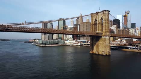 Vista-aérea-del-centro-de-la-ciudad-de-Nueva-York,-América.-Drone-volando-bajo-el-puente-de-Brooklyn-a-través-del-río-del-este