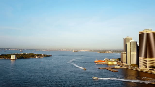 Vista-aérea-del-distrito-de-Manhattan-en-Nueva-York,-América.-Este-río,-Governors-island-y-estatua-de-la-libertad-en-el-horizonte