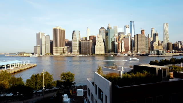 Vista-aérea-de-mujer-joven-de-pie-en-el-muelle-de-Brooklyn-park,-drone-volando-a-Manhattan-en-Nueva-York,-América