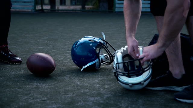 American-football-players-preparing-helmets