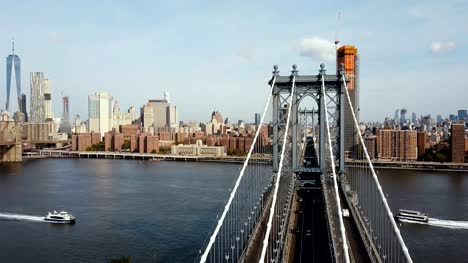 Aerial-view-on-Manhattan-bridge-in-New-York,-America.-Drone-flying-over-the-East-river,-boat-riding-through