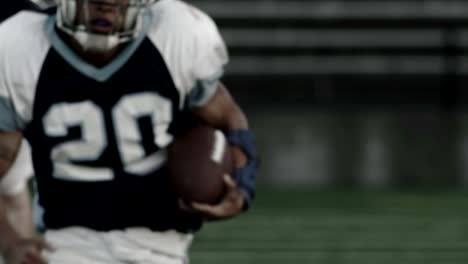 Close-up-of-a-running-back-sprinting-down-the-field-with-the-ball