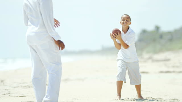 Ethnic-boy-playing-American-football-with-his-father